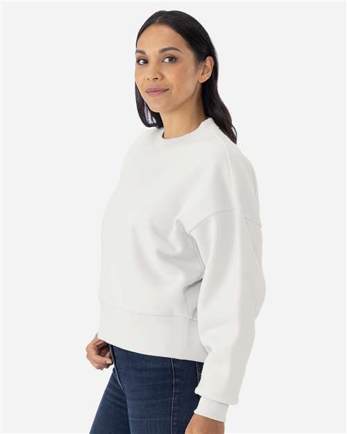 Bone - Next Level 9087 Women's Sweatshirt with Logo Embroidery Next Level Women's Heavyweight Crewneck Sweatshirt in Bone, side view on model