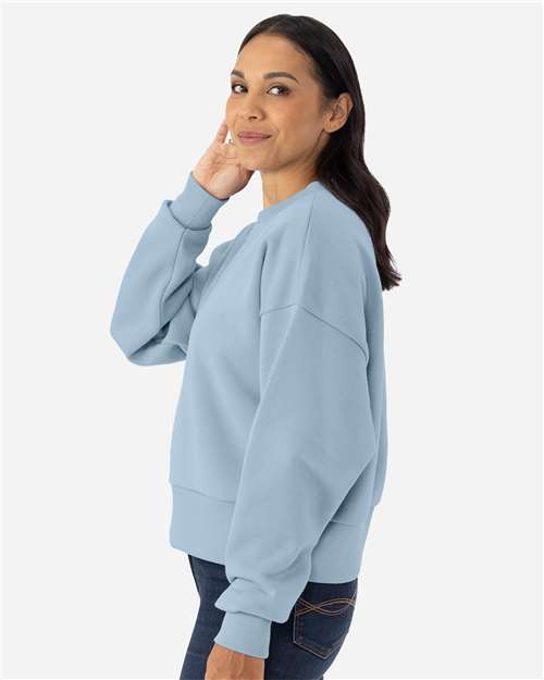 Stonewash Denim - Next Level 9087 Women's Sweatshirt with Logo Embroidery Next Level Women's Heavyweight Crewneck Sweatshirt in Stonewash Denim, side view on model