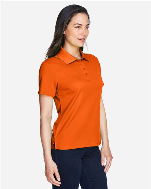 Campus Orange - CORE365 78181 Women's Polo with Embroidered Company Logo CORE365 Women’s Polo in Campus Orange, side view on model